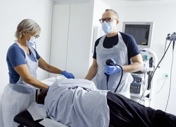 En læge og en sygeplejerske undersøger en patient